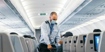 man in blue dress shirt standing in airplane