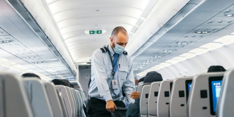 man in blue dress shirt standing in airplane