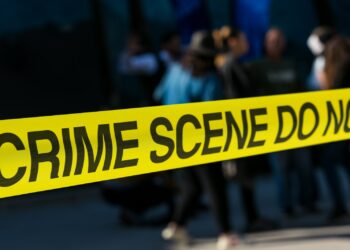 a group of people standing next to a yellow police line