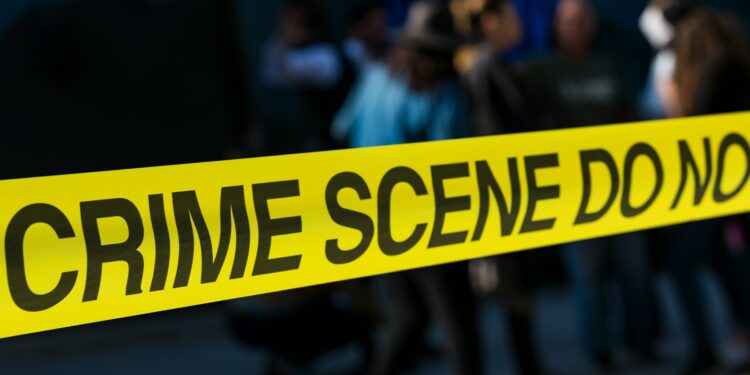 a group of people standing next to a yellow police line