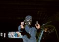 a person sitting on a car holding a camera