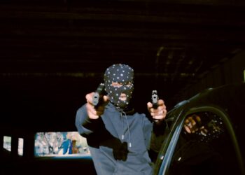a person sitting on a car holding a camera