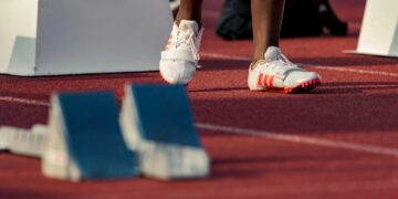person standing beside white stand